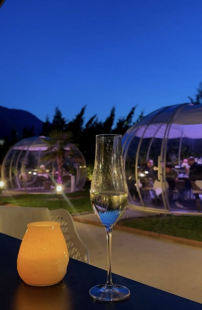 Un verre sur la terrasse à la tombée de la nuit, face aux igloos
